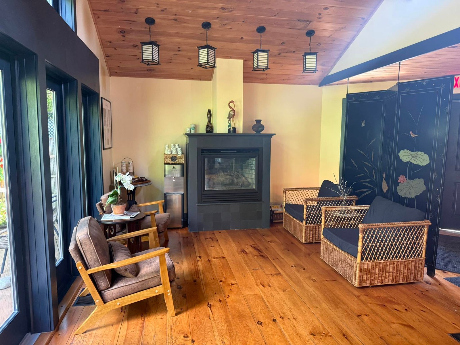 Warm lounge with fireplace, seating, and woodland views at InTouch