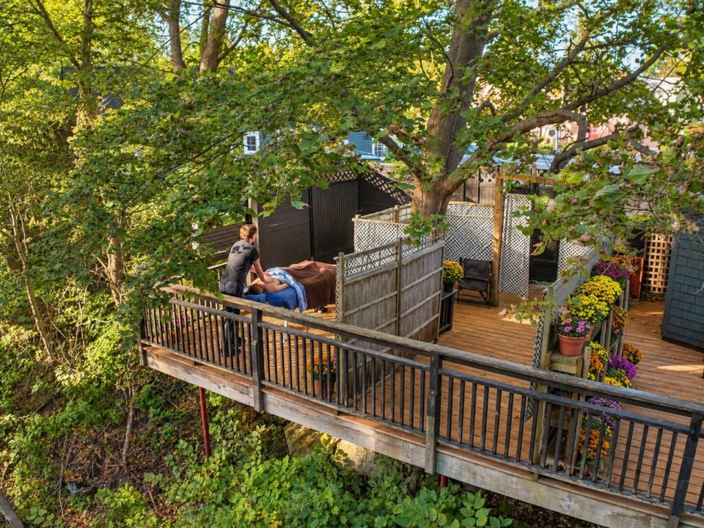 Therapist giving a massage to a draped participant on InTouch’s outdoor deck